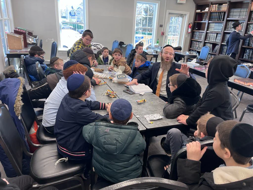 Rabbi Scheller learning with students around a classroom table