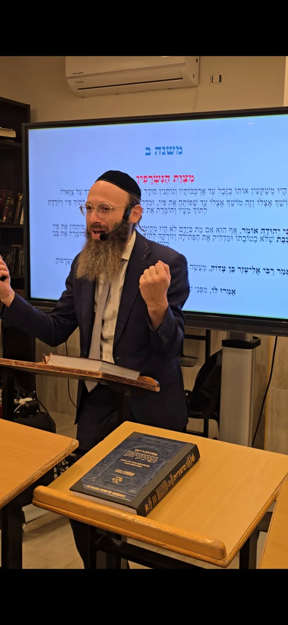 Rabbi Scheller teaching beside a Mishnah text display